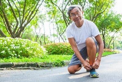 Older man tying his shoe