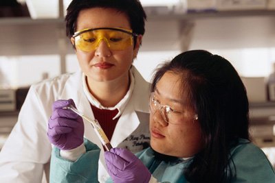 Two scientists examining a vial containing a blood sample