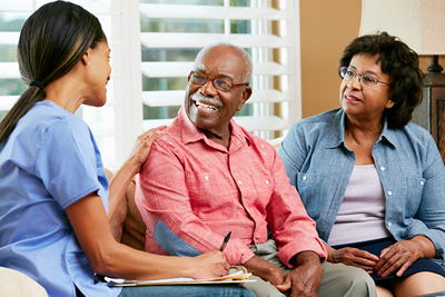 An older man and his wife talk to a home health care provider