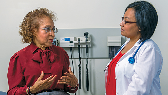 Older woman talking to her doctor about pain