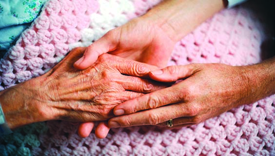 2 people holding hands on a pink blanket