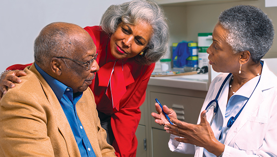 Older African American couple discuss vaccinations with their doctor