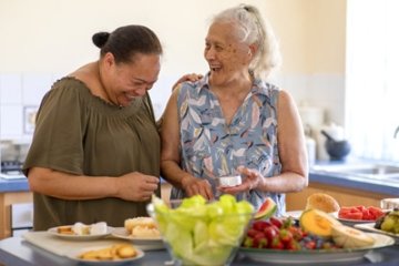 Two older adults preparing a healthy meal together.