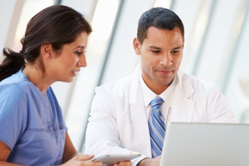 Health care providers reviewing Alzheimer's resources on a laptop