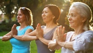 Women outside in park participating in Tai Chi.