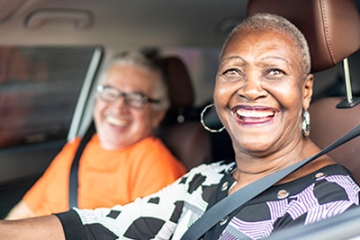 Older adult women driving a car with a friend who has Alzheimer's