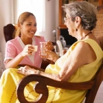 Older woman with Alzheimer's in a care facility with a caregiver
