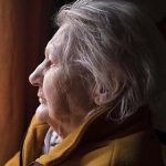 Older woman with depression looking out a window