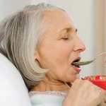 older woman being fed healthy food