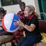 Group of older adults playing seated volleyball with a beach ball