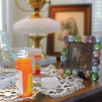 Medication bottles on a table by the bed of someone dying at home.