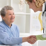 Older woman shaking hands with a doctor