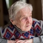 Older woman with Alzheimer's looking out a window