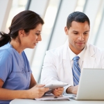 Health care providers reviewing Alzheimer's resources on a laptop.