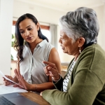 Young woman discussing documents with her grandmother